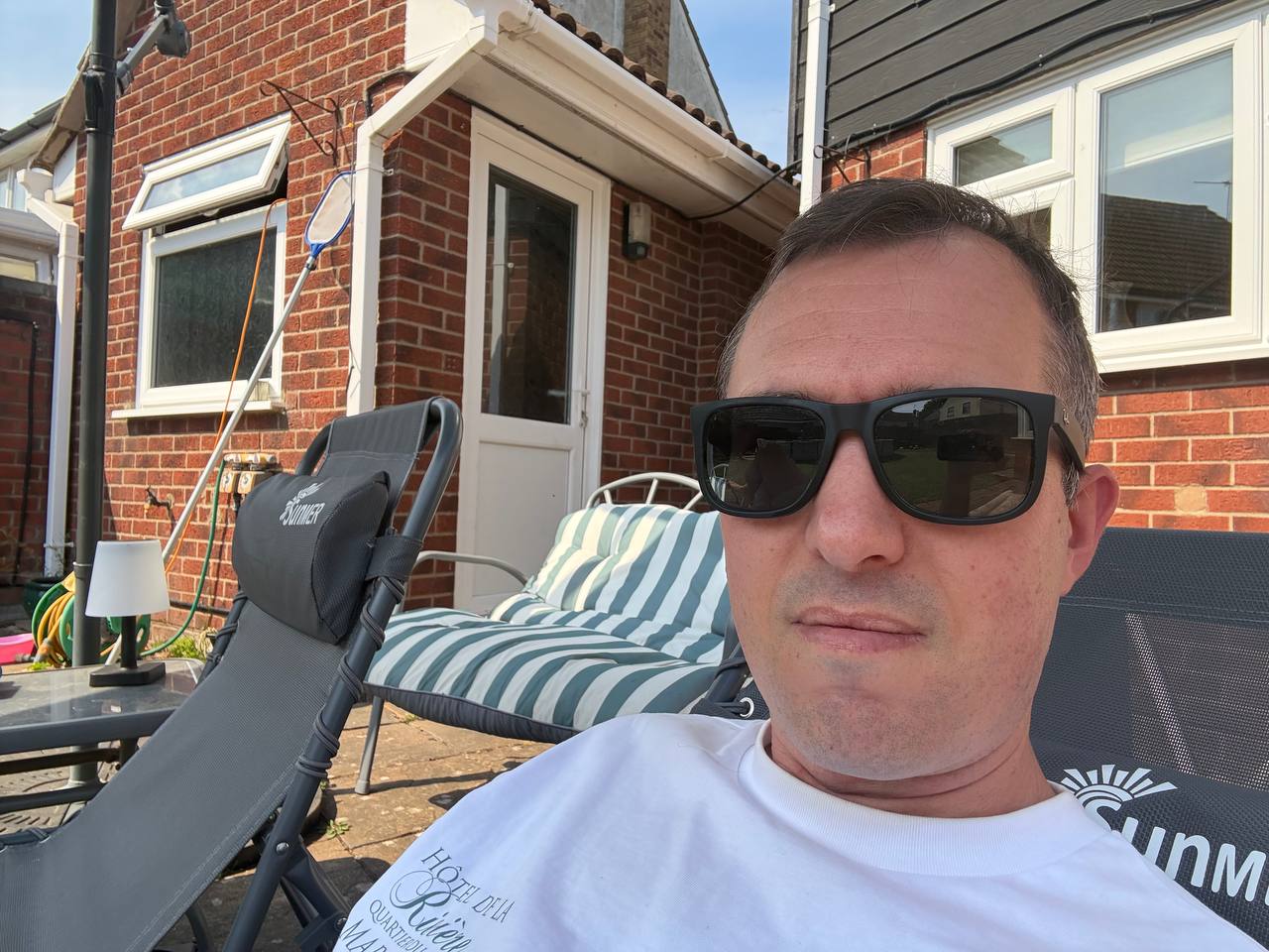 Dan sitting in the garden with his phone, showing he can publish blog posts from anywhere